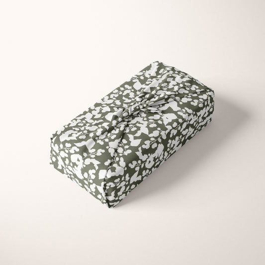 Folded fabric with a green and white pattern on a light cream background