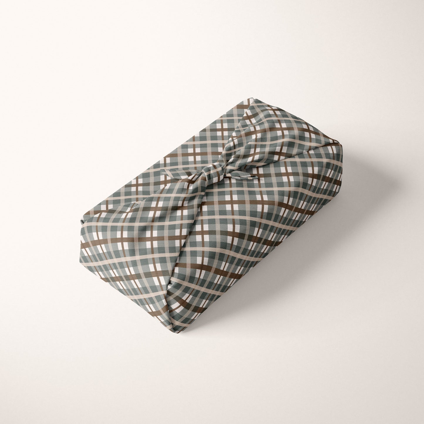 Green Plaid fabric wrapped gift on a white background