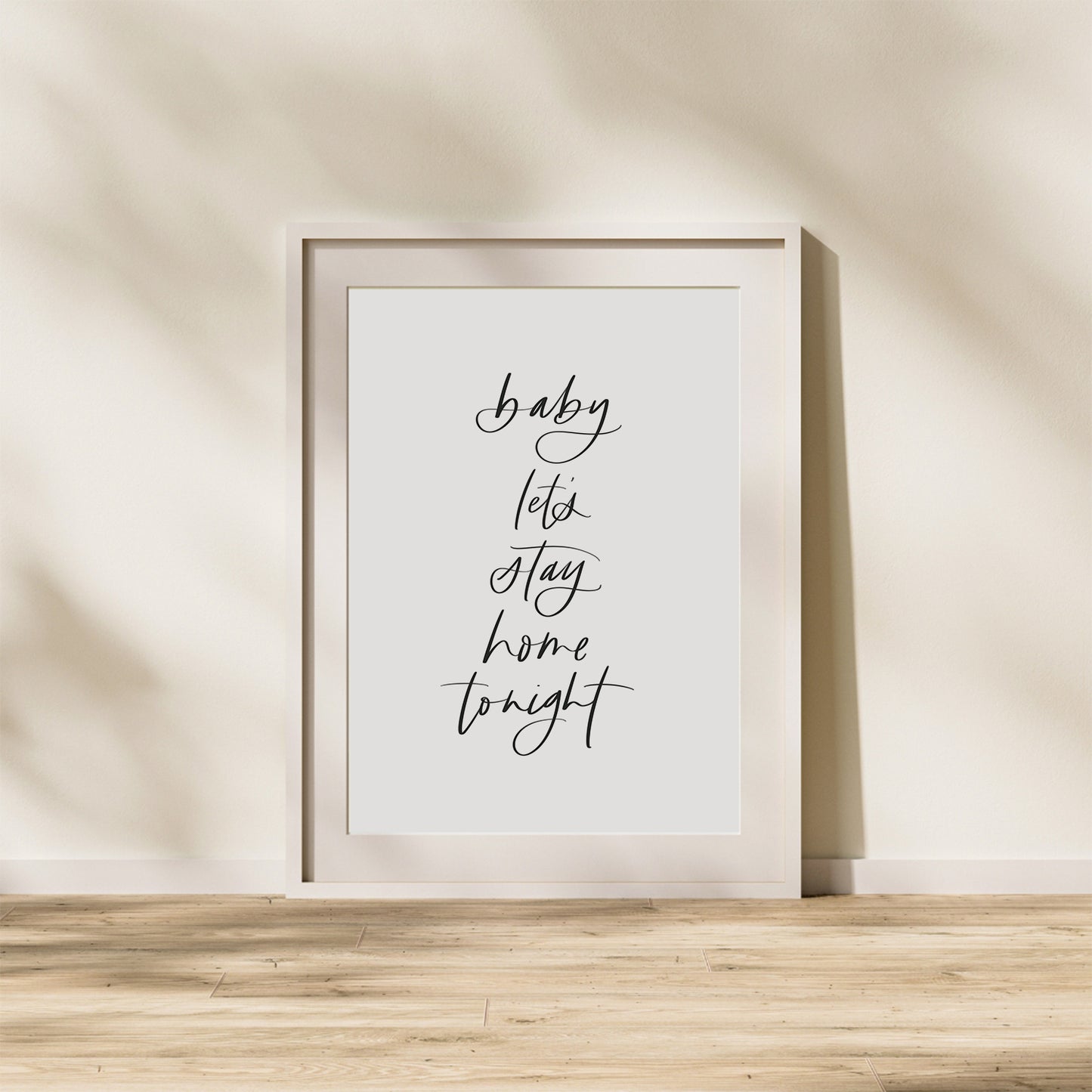 Framed print with 'baby, let's stay home tonight' text on a neutral wall.