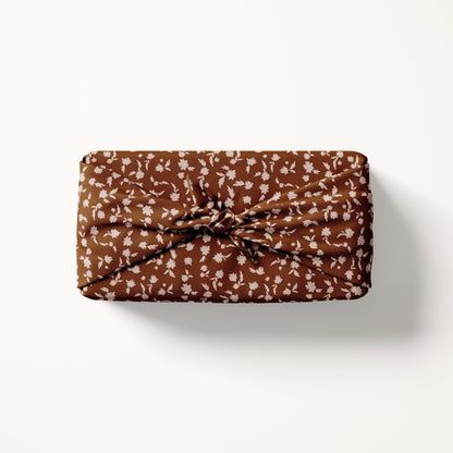 red fabric wrap with blush florals on cream background