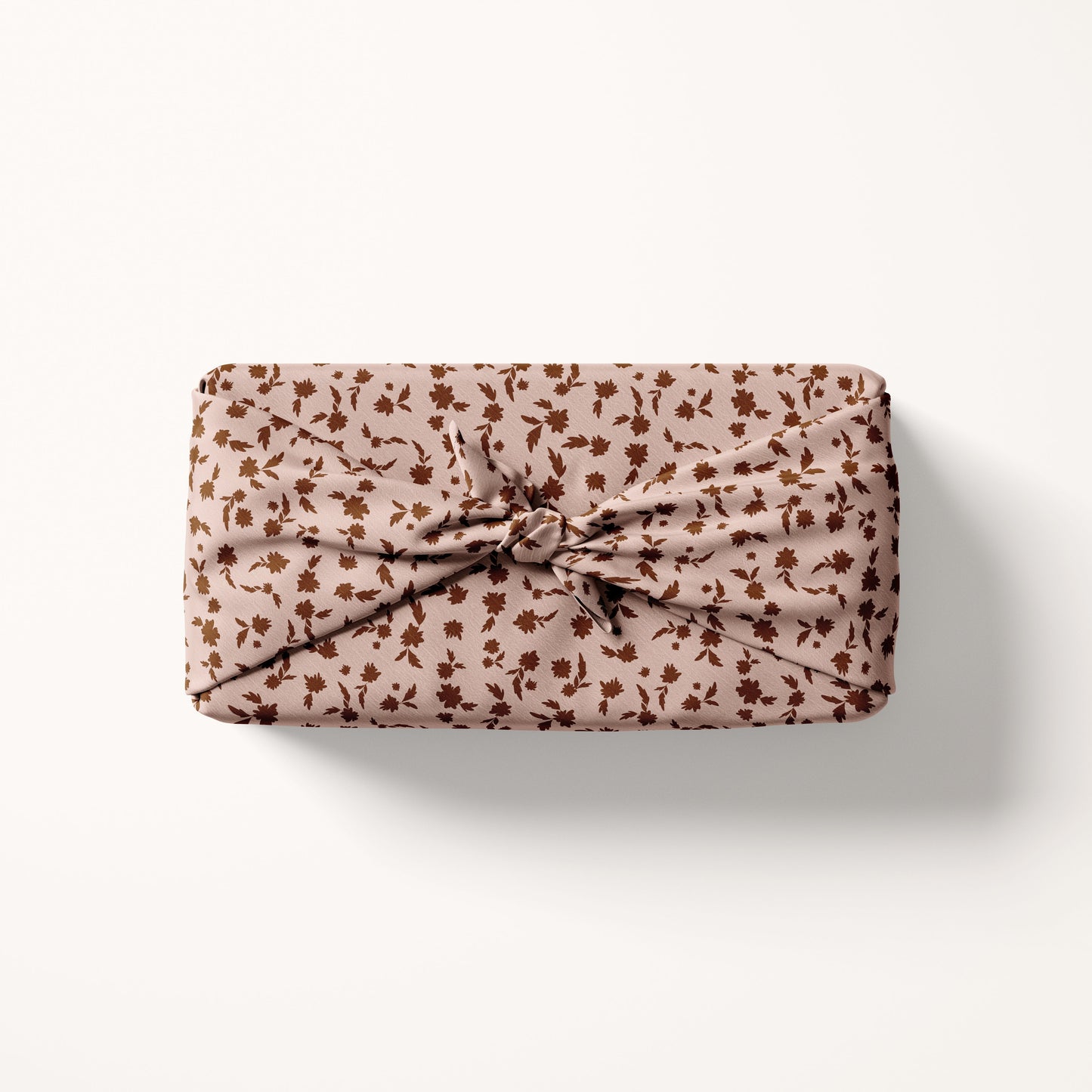 Christmas floral fabric wrapped gift on a white background