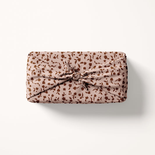 Christmas floral fabric wrapped gift on a white background