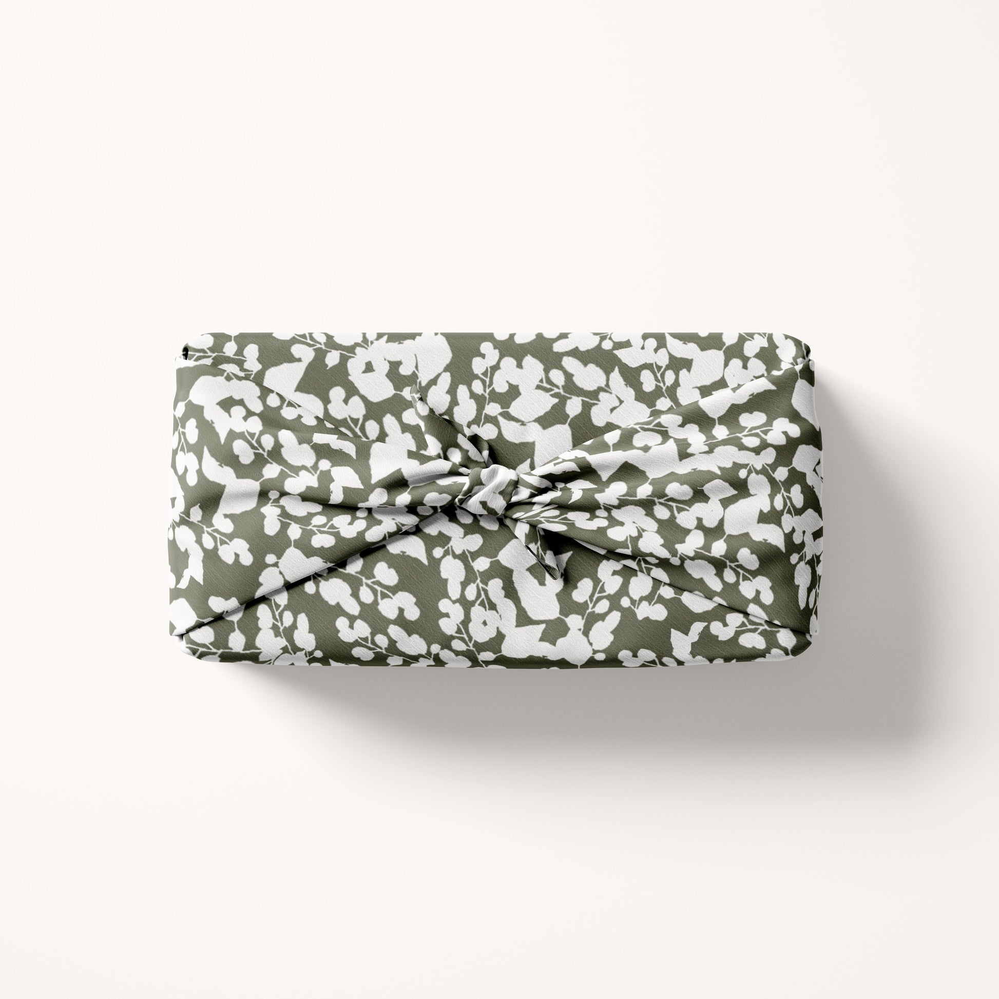 fabric gift wrap in white and green on cream background