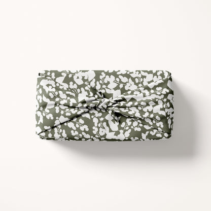 fabric gift wrap in white and green on cream background