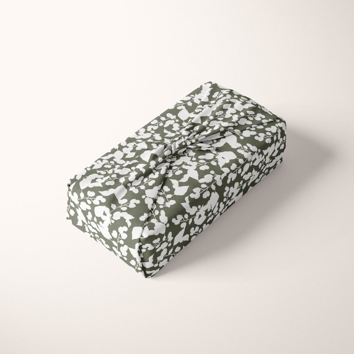 Folded fabric with a green and white pattern on a light cream background