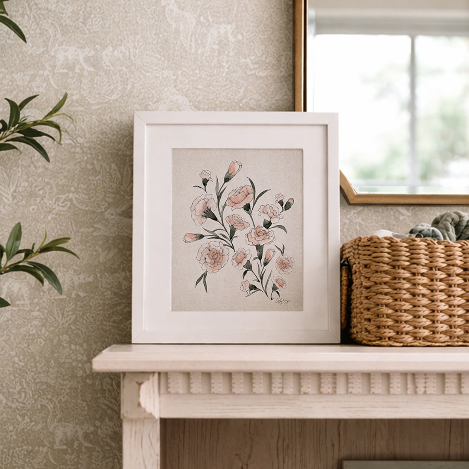 January carnation birth flowers painting artwork in a white frame on a wooden bookshelf with a neutral wall and basket next to it.