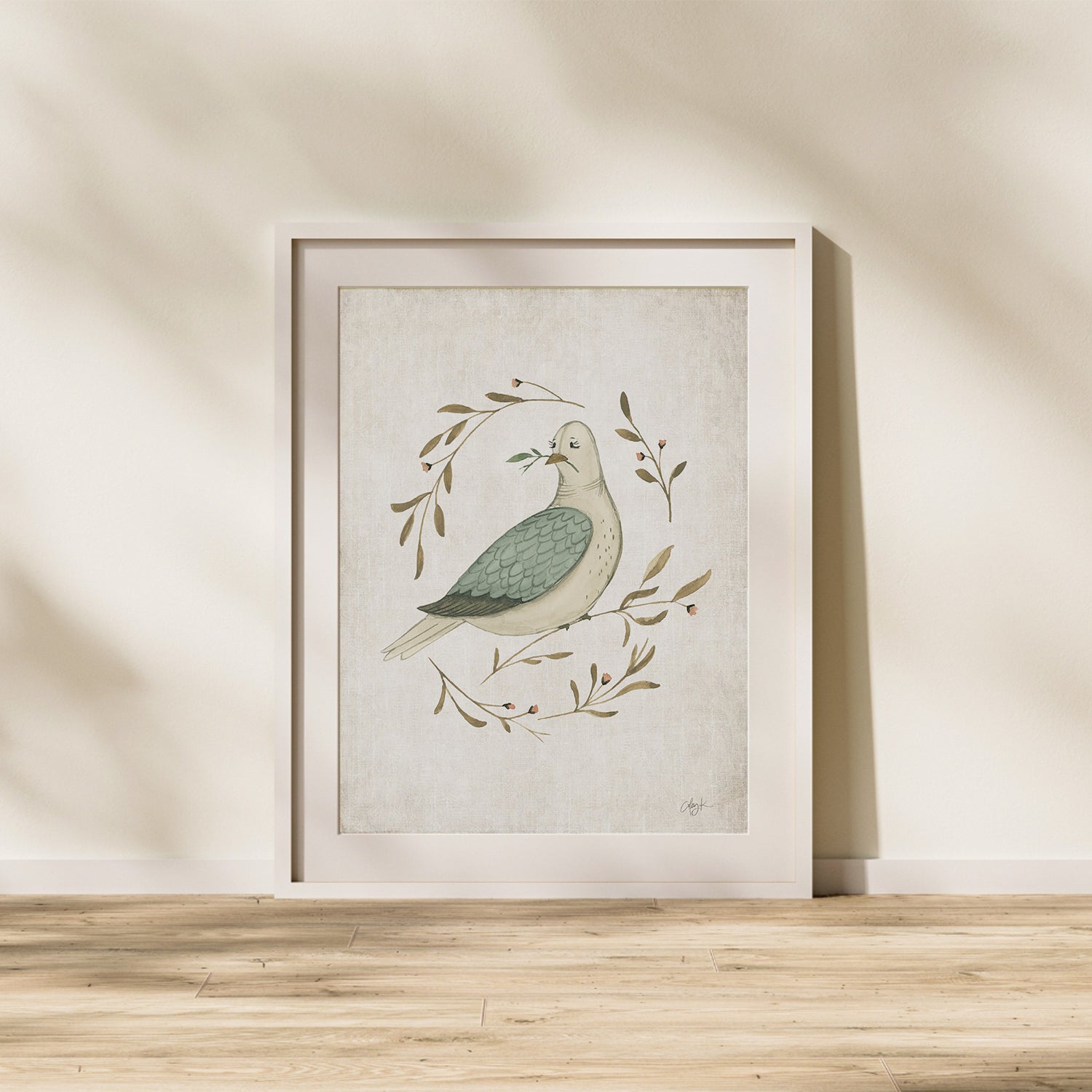 Framed artwork of a dove with leaves on a beige wall. watercolor dove peace on earth christmas art print